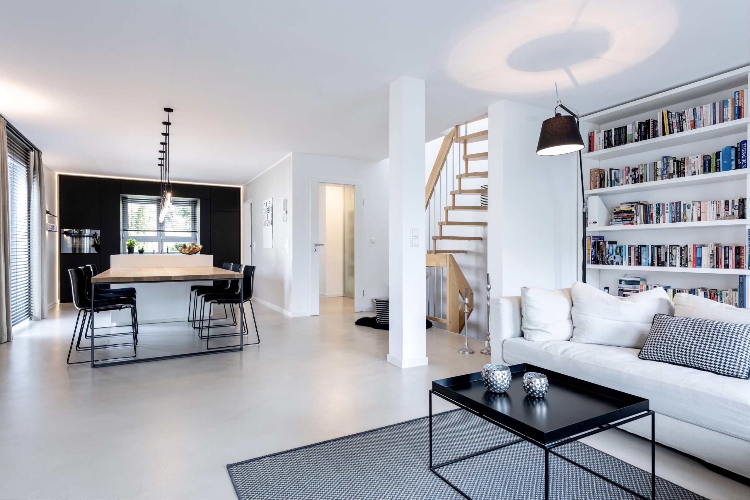 Helle Wohnküche, Bücherwand, moderne Treppe.