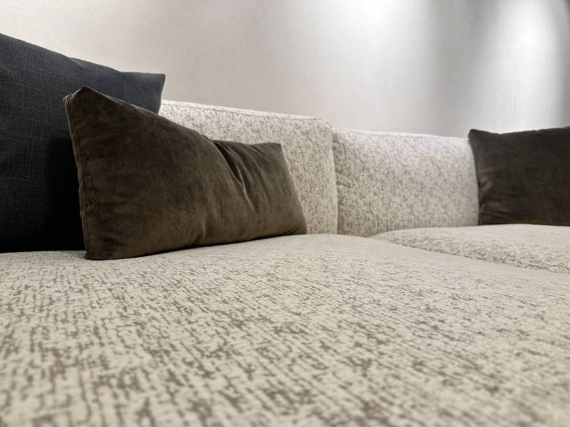 Nahaufnahme graue Couch, samtige Kissen.