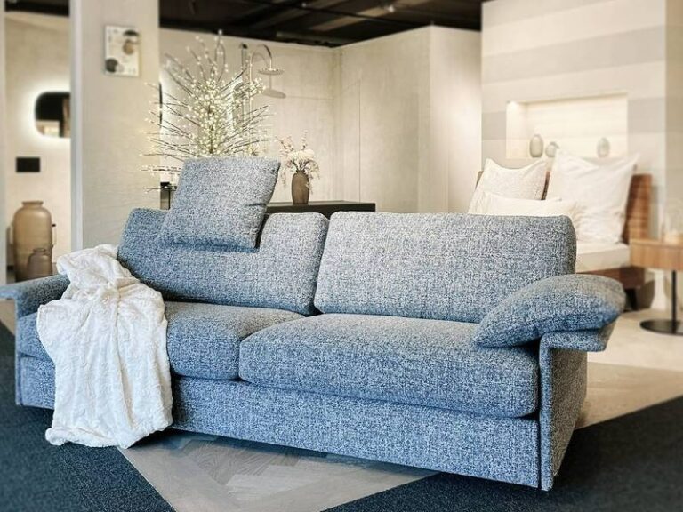 Blaue Couch, weiße Decke, gemütlich.
