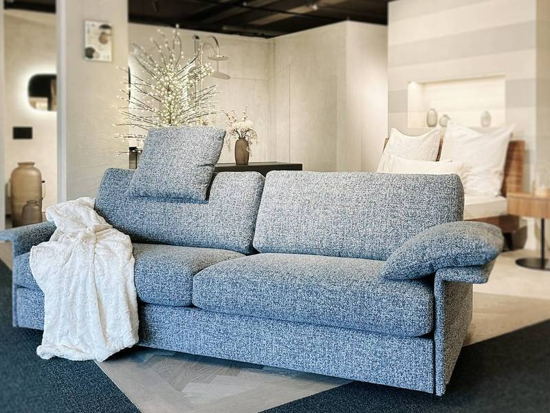 Blaue Couch, weiße Decke, gemütlich.