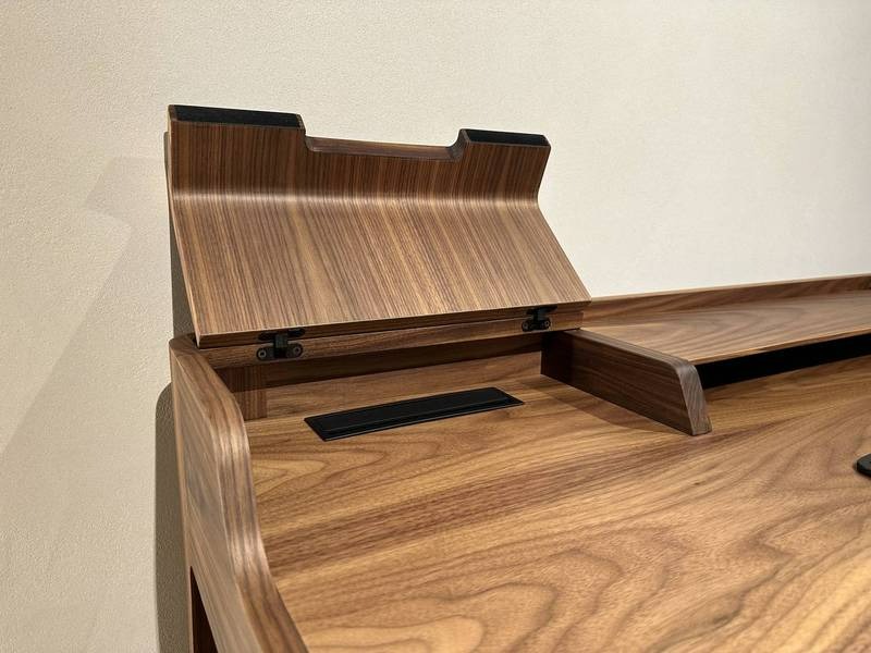 Geöffnete Holzklappe auf elegantem Schreibtisch.