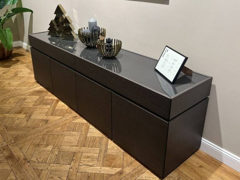 Dunkles Sideboard, goldene Dekoelemente, Parkett.