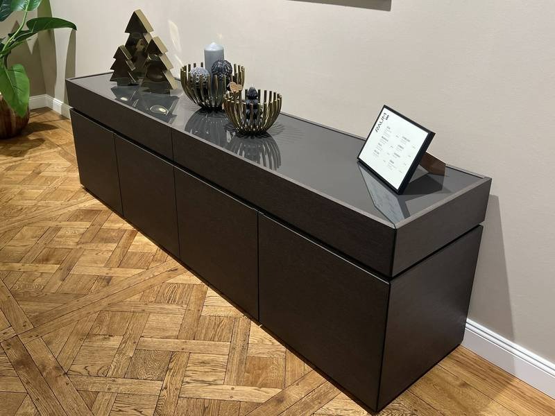 Dunkles Sideboard, goldene Dekoelemente, Parkett.