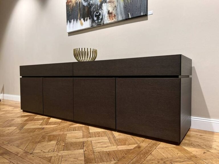 Dunkles Sideboard, Parkett, goldene Schale.