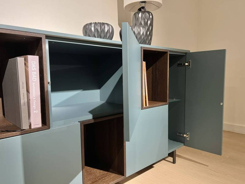 Blaues Sideboard, offene Türen, Bücher.