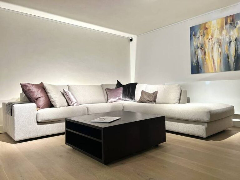 Ecksofa, Kunstbild, dezente Beleuchtung, Kissen.