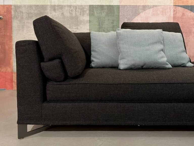 Dunkles Sofa, blaue Kissen, Retro-Wand.