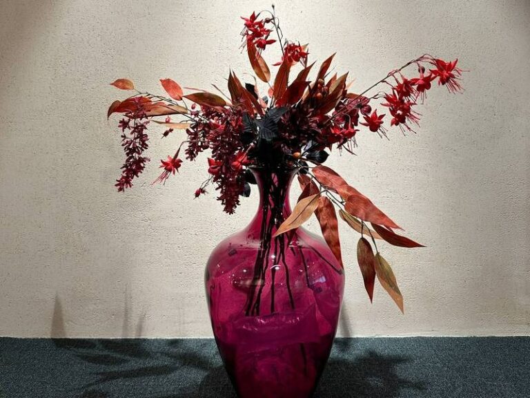Rote Blätter in pinker Vase.