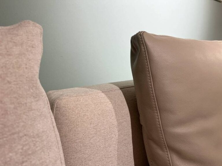 Stoff- und Lederkissen auf Sofa.