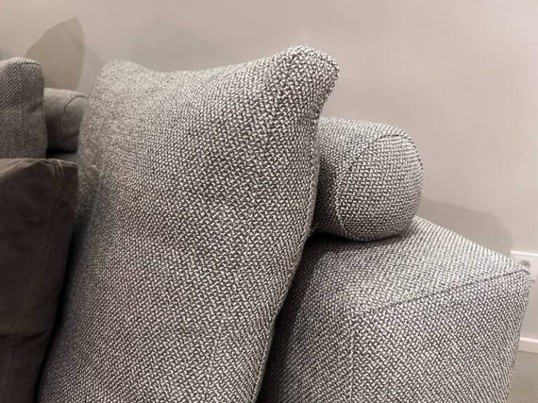 Grau melierte Kissen auf Sofa.