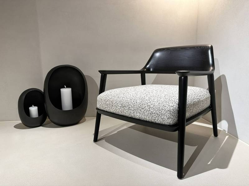 Schwarzer Stuhl, Kerzen, minimalistisches Design.