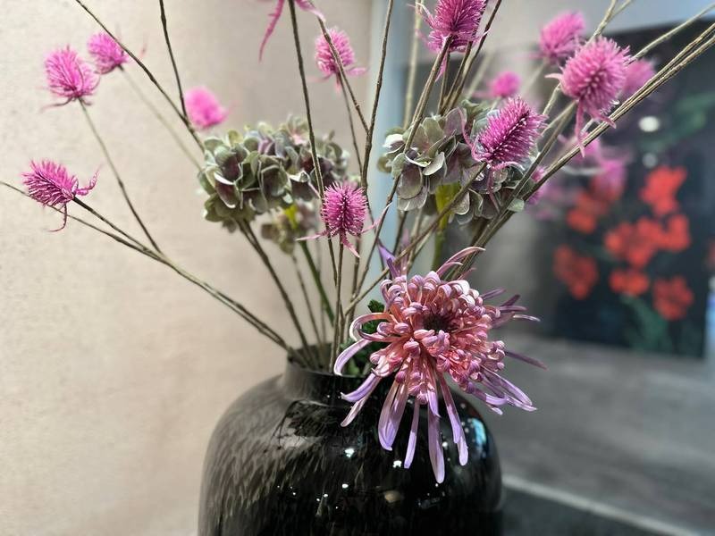 Schwarze Vase, rosa Blumenarrangement, modern.